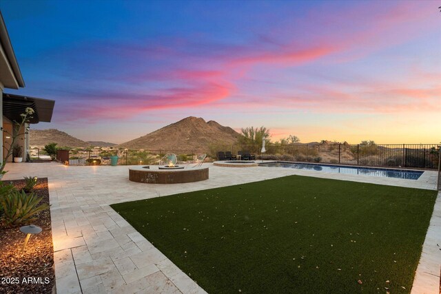 6535 W Gold Mountain Pass, Phoenix, AZ 85083 - yard at dusk with a fire pit, a patio, a fenced backyard, a mountain view, and a pool with connected hot tub