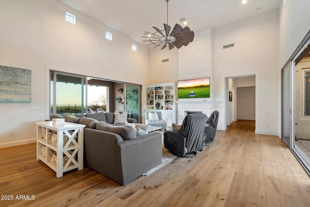 6535 W Gold Mountain Pass, Phoenix, AZ 85083 - living room featuring light wood-style floors, baseboards, a high ceiling, and visible vents