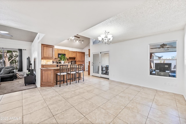 7949 W Pershing Ave, Peoria, AZ 85381 - kitchen with open floor plan, light tile patterned floors, a textured ceiling, a breakfast bar, and vaulted ceiling