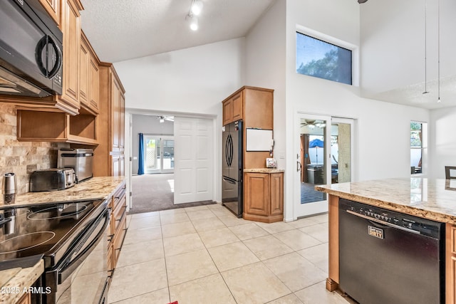 7949 W Pershing Ave, Peoria, AZ 85381 - kitchen with black appliances, a ceiling fan, high vaulted ceiling, plenty of natural light, and light stone counters