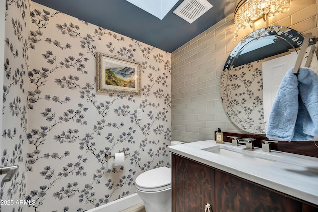 3109 E Sierra Madre Way, Phoenix, AZ 85016 - half bathroom featuring wallpapered walls, vanity, and a skylight