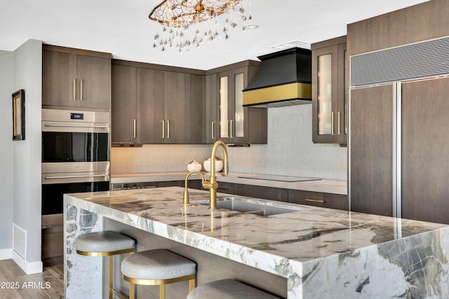 3109 E Sierra Madre Way, Phoenix, AZ 85016 - kitchen featuring custom range hood, paneled built in fridge, stainless steel double oven, tasteful backsplash, and wood finished floors