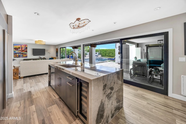 3109 E Sierra Madre Way, Phoenix, AZ 85016 - kitchen with wine cooler, light wood-style flooring, an island with sink, open floor plan, and stainless steel dishwasher
