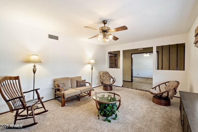 living area with carpet flooring, visible vents, and ceiling fan