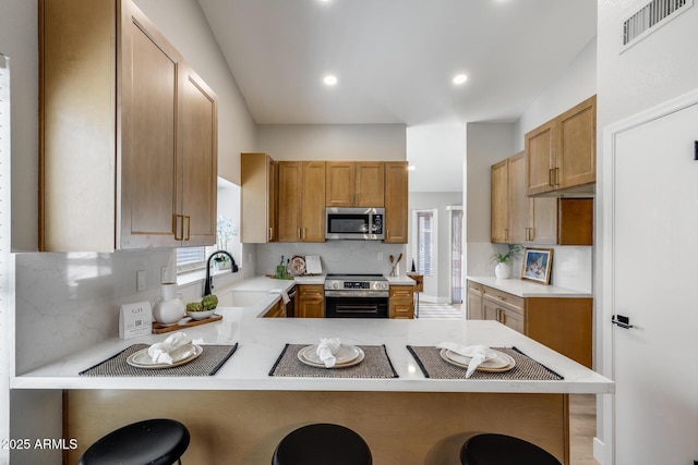 2730 E Desert Trumpet Rd, Phoenix, AZ 85048 - kitchen with appliances with stainless steel finishes, a sink, a breakfast bar, light countertops, and recessed lighting