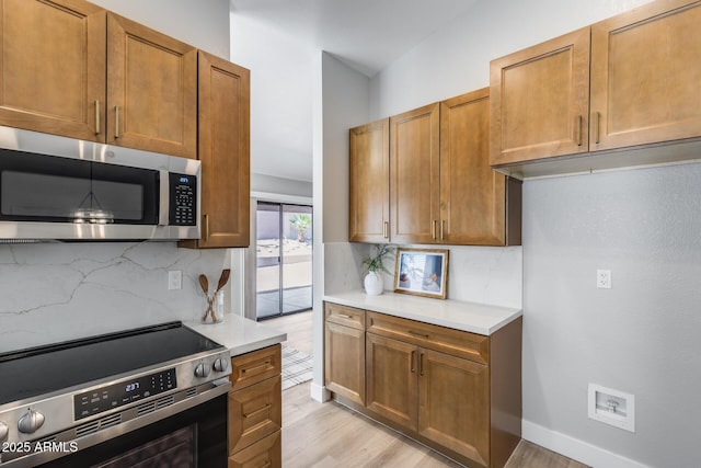 2730 E Desert Trumpet Rd, Phoenix, AZ 85048 - kitchen featuring stainless steel appliances, light countertops, decorative backsplash, and light wood-type flooring