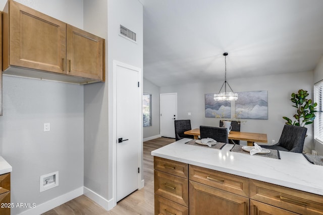 2730 E Desert Trumpet Rd, Phoenix, AZ 85048 - kitchen with baseboards, light wood-style flooring, brown cabinets, and light stone countertops