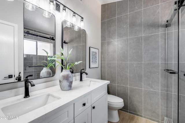 2730 E Desert Trumpet Rd, Phoenix, AZ 85048 - full bathroom featuring tile walls, double vanity, toilet, wood finished floors, and tiled shower