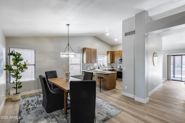 2730 E Desert Trumpet Rd, Phoenix, AZ 85048 - dining room with baseboards, lofted ceiling, light wood-type flooring, and a chandelier