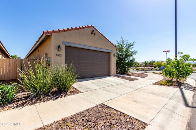 14233 W Georgia Dr, Surprise, AZ 85379 - view of property exterior featuring stucco siding, driveway, a tile roof, and a garage