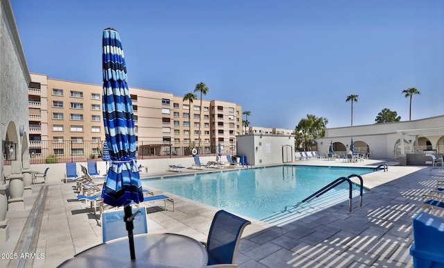 pool with fence and a patio