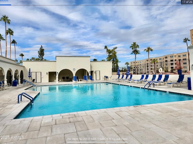 pool with a patio area and fence