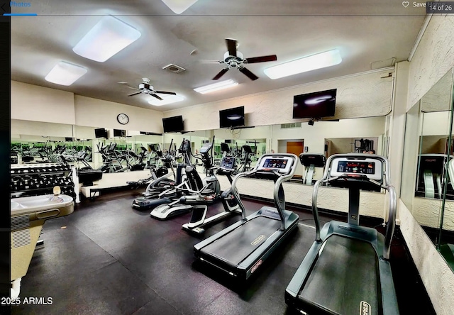 gym with a textured wall, visible vents, and a ceiling fan