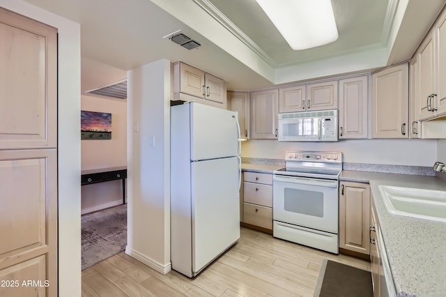 kitchen with light wood-style flooring, white appliances, a sink, visible vents, and a tray ceiling