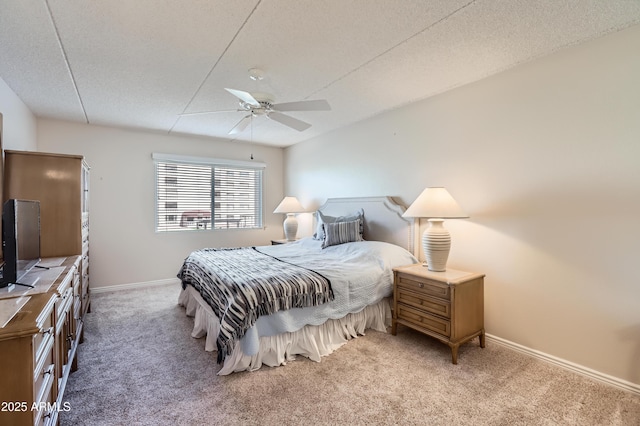 carpeted bedroom featuring ceiling fan, a textured ceiling, and baseboards