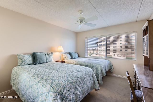 bedroom featuring a textured ceiling, carpet floors, a ceiling fan, and baseboards