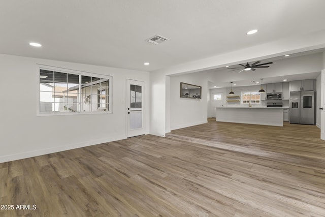 unfurnished living room with light wood-style floors, recessed lighting, visible vents, and a ceiling fan