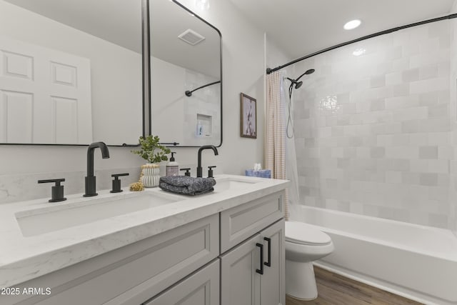 bathroom featuring toilet, shower / tub combo, visible vents, and a sink