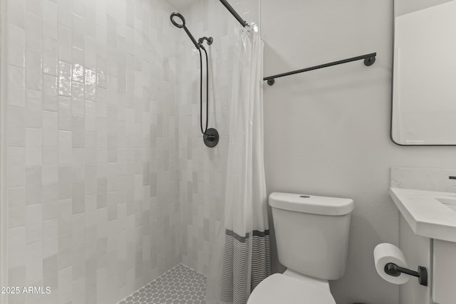 full bathroom featuring a tile shower and toilet