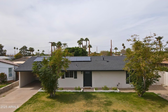 single story home featuring roof with shingles, solar panels, stucco siding, a carport, and a front lawn