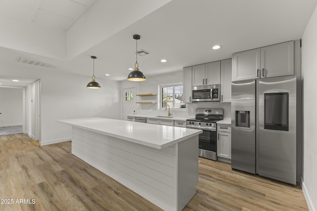 kitchen with stainless steel appliances, light countertops, visible vents, and light wood-style floors