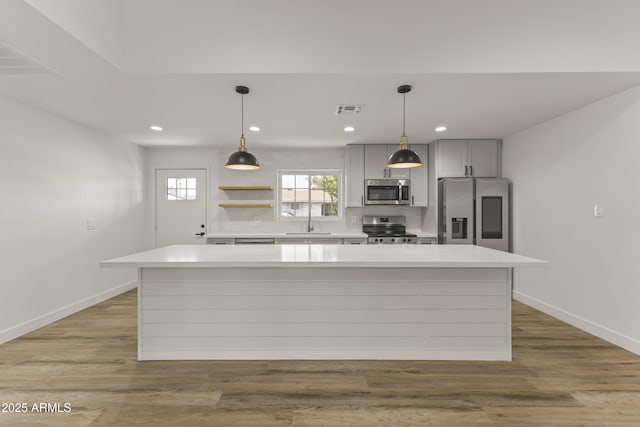 kitchen featuring stainless steel appliances, light wood-style flooring, light countertops, and visible vents