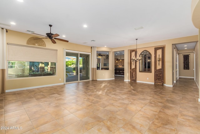 unfurnished living room featuring ceiling fan with notable chandelier