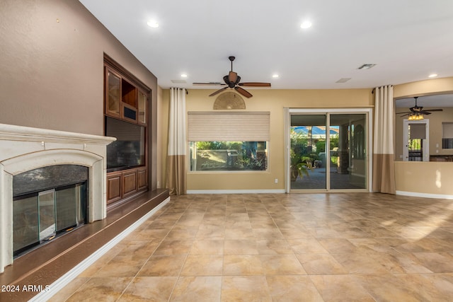 unfurnished living room featuring light tile patterned floors, a fireplace, and ceiling fan