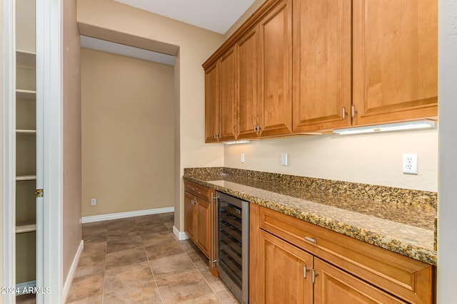 kitchen featuring light tile patterned flooring, light stone countertops, and wine cooler