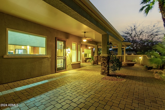 patio terrace at dusk featuring ceiling fan