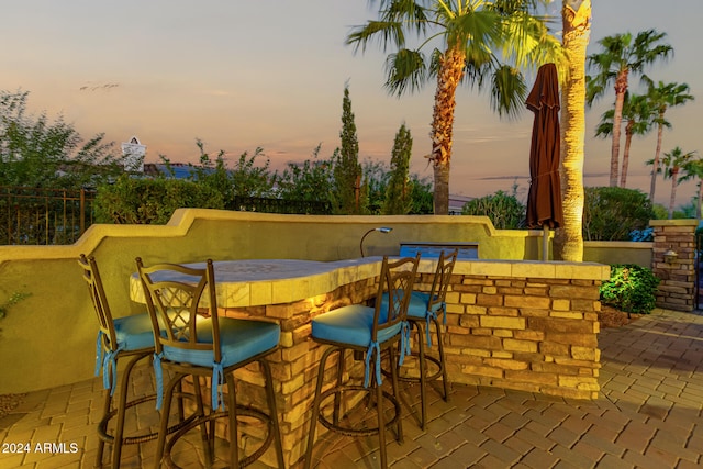 patio terrace at dusk featuring exterior bar