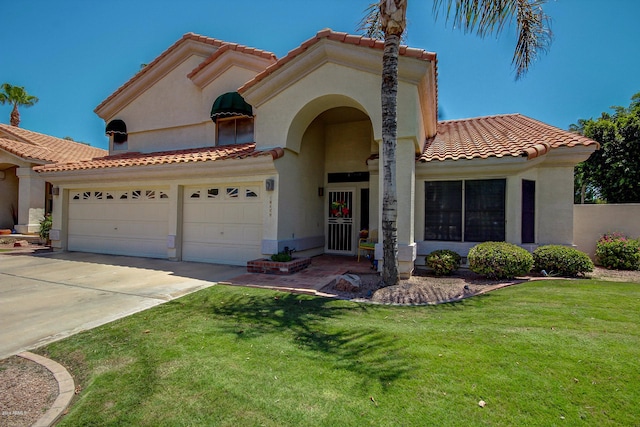 mediterranean / spanish home featuring a garage and a front lawn