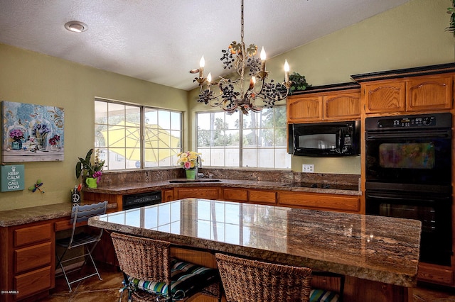 kitchen with black appliances, vaulted ceiling, sink, a kitchen island, and a chandelier