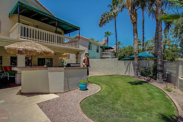 view of yard with a balcony and exterior bar