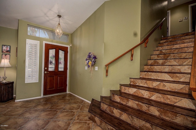 entryway with dark tile patterned floors