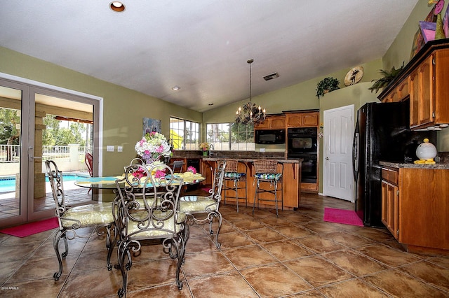 dining area with french doors, tile patterned flooring, vaulted ceiling, and a chandelier