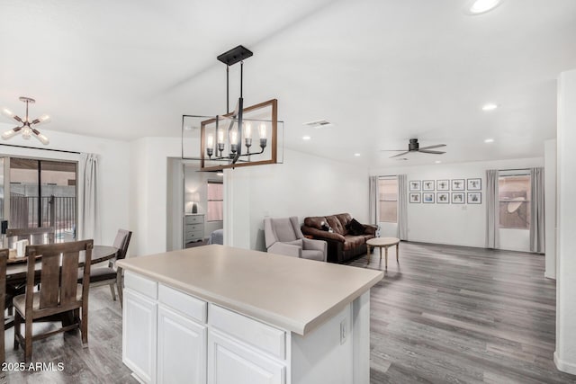 kitchen with a kitchen island, dark hardwood / wood-style floors, pendant lighting, and white cabinets