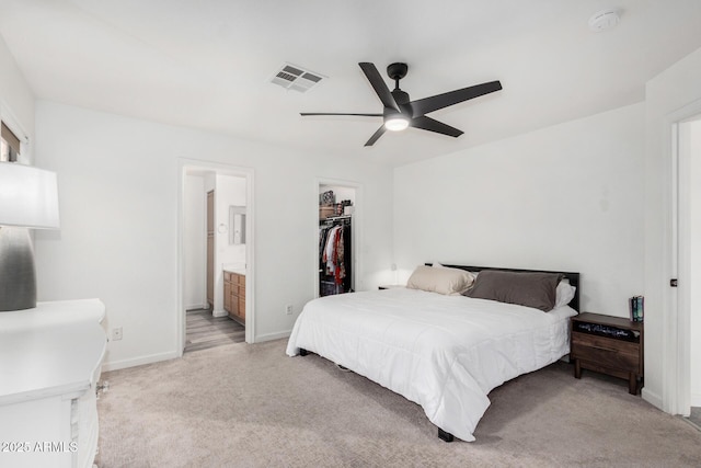 carpeted bedroom with ceiling fan, ensuite bathroom, a spacious closet, and a closet