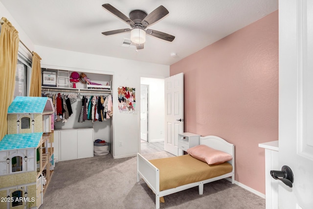 bedroom featuring ceiling fan, a closet, and light carpet