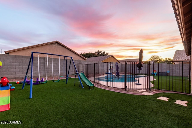 playground at dusk with a fenced in pool and a lawn