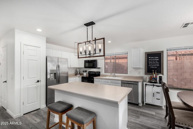 kitchen featuring a center island, sink, white cabinets, and black appliances