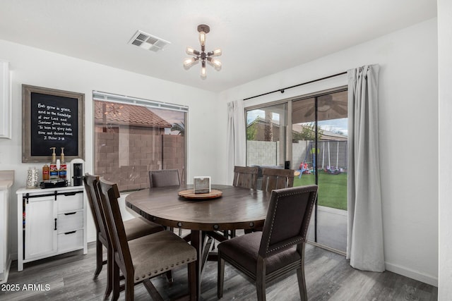 dining space featuring dark hardwood / wood-style flooring and a chandelier