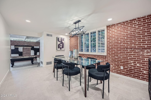 dining space with brick wall and an inviting chandelier