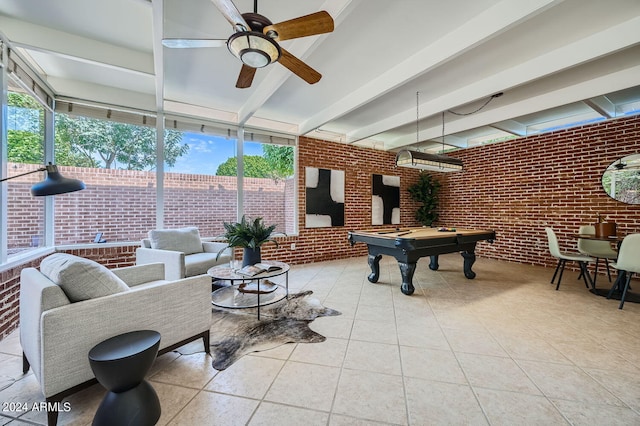 interior space with beam ceiling, ceiling fan, brick wall, and billiards