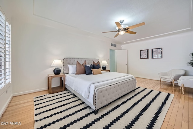 bedroom featuring light hardwood / wood-style flooring, multiple windows, and ceiling fan