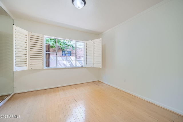 unfurnished room featuring light hardwood / wood-style flooring and crown molding