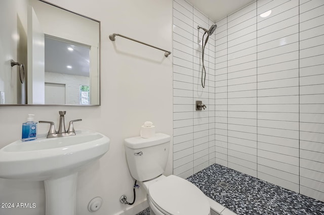 bathroom featuring a tile shower and toilet