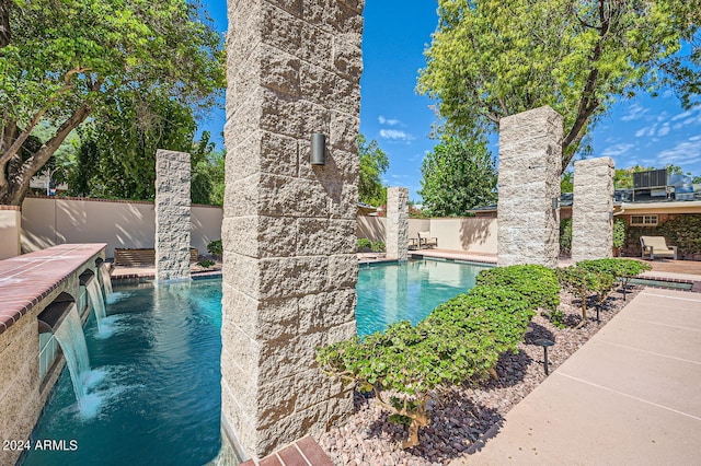 view of swimming pool with pool water feature