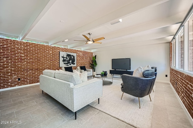 living room with beam ceiling, ceiling fan, and brick wall