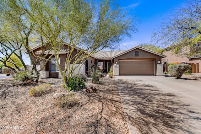 view of front of property with stucco siding, a garage, and driveway